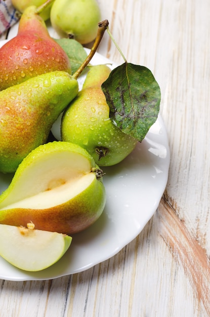 Fresh peaches in white plate on wooden