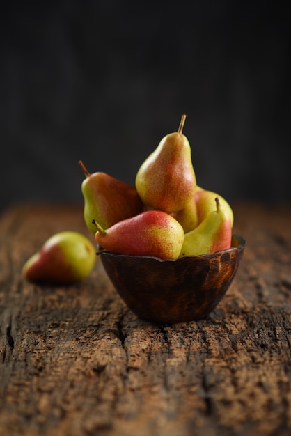 Fresh pear fruits on wooden bowl