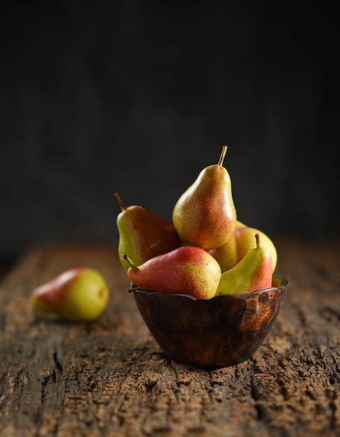 Fresh pear fruits on wooden bowl