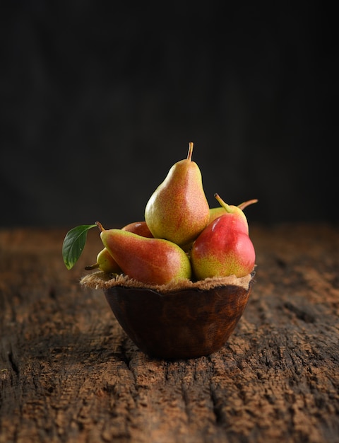 Fresh pear fruits on wooden bowl