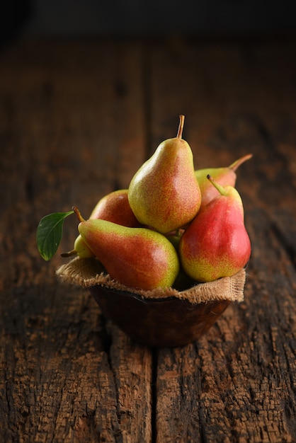 Fresh pear fruits on wooden bowl