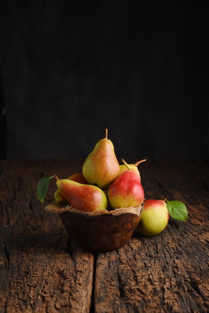 Fresh pear fruits on wooden bowl