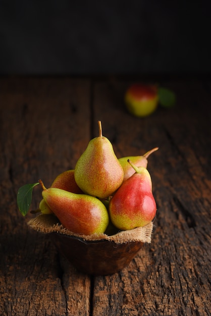 Fresh pear fruits on wooden bowl