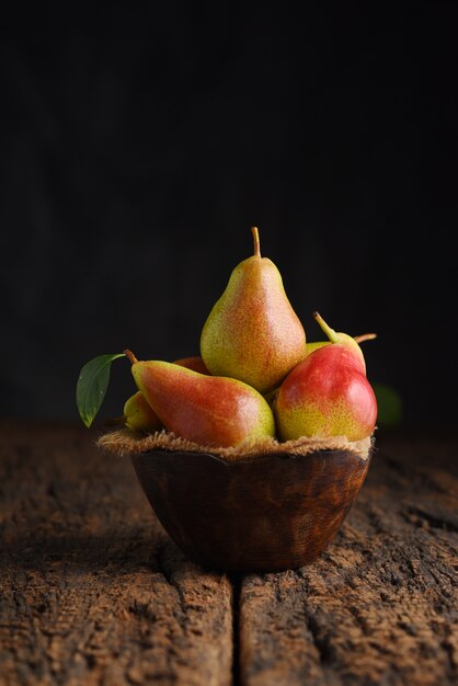 Fresh pear fruits on wooden bowl