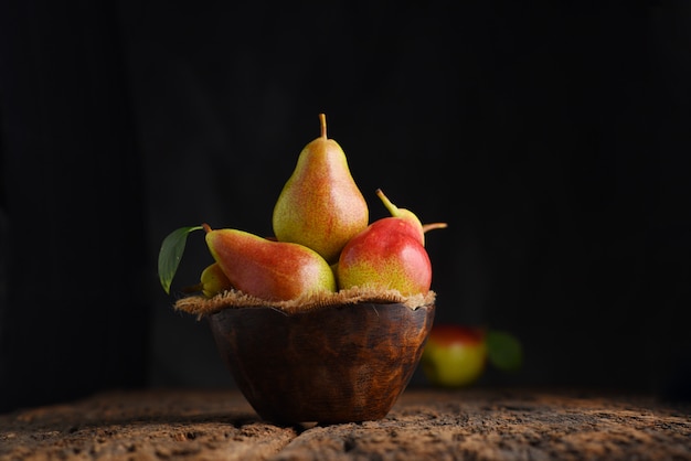 Fresh pear fruits on wooden bowl