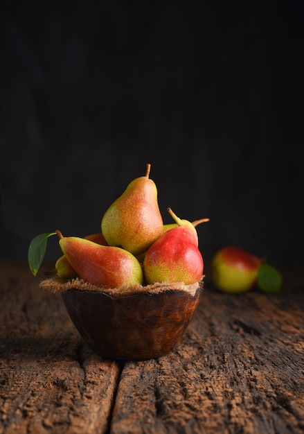 Fresh pear fruits on wooden bowl