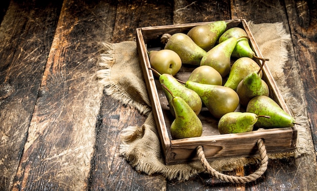 Fresh pears onn old tray on wooden table.