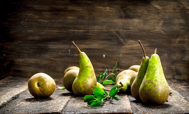 Photo fresh pears with leaves on wooden table.