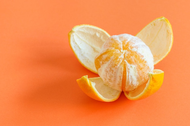 Foto arange sbucciato fresco sui precedenti corallo, preparato per mangiare. dieta sana a base di frutta.