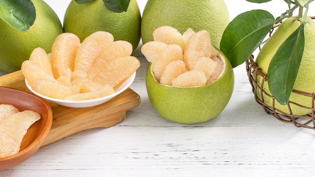 Fresh peeled pomelo, pummelo, grapefruit, shaddock on bright wooden table background. Seasonal fruit for Mid-Autumn Festival, close up, copy space.