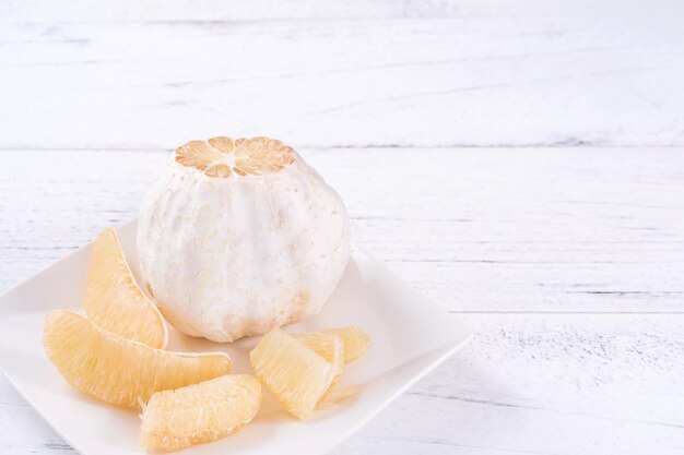 Fresh peeled pomelo pummelo grapefruit shaddock on bright wooden table background Seasonal fruit for MidAutumn Festival close up copy space