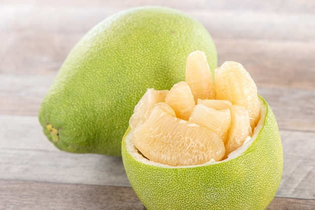 Fresh and peeled pomelo(shaddock), grapefruit with slices on wooden table background