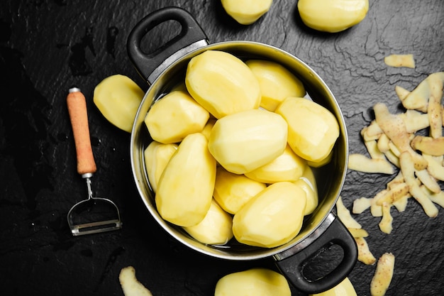 Fresh peeled potatoes On a black background