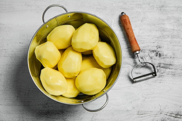 Foto patate fresche sbucciate su un tavolo bianco