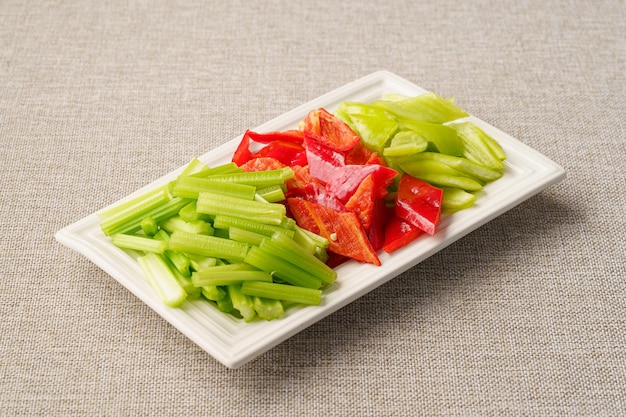 Fresh peppers and celery on a simple background