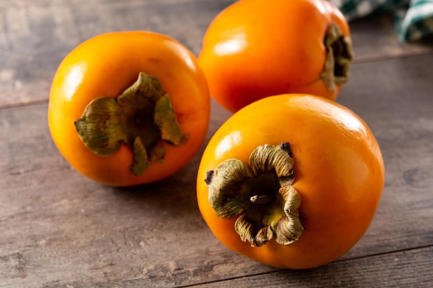 Fresh persimmon fruit on wooden table