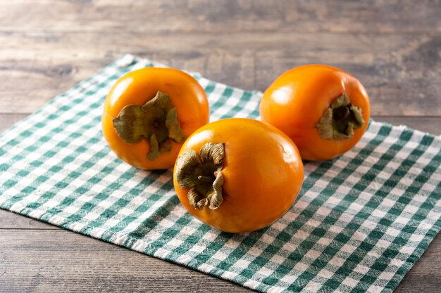 Fresh persimmon fruit on wooden table