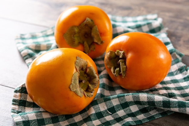 Fresh persimmon fruit on wooden table