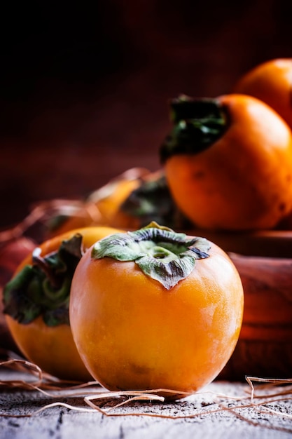 Fresh persimmons vintage wooden background selective focus