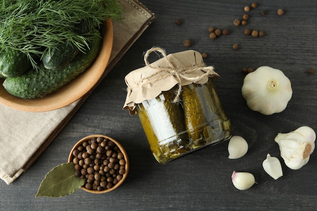 Fresh pickles and ingredients on dark wooden table