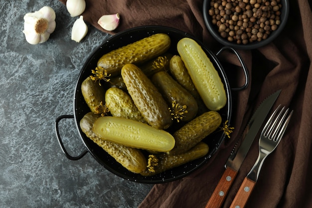 Fresh pickles and spices on black smokey table