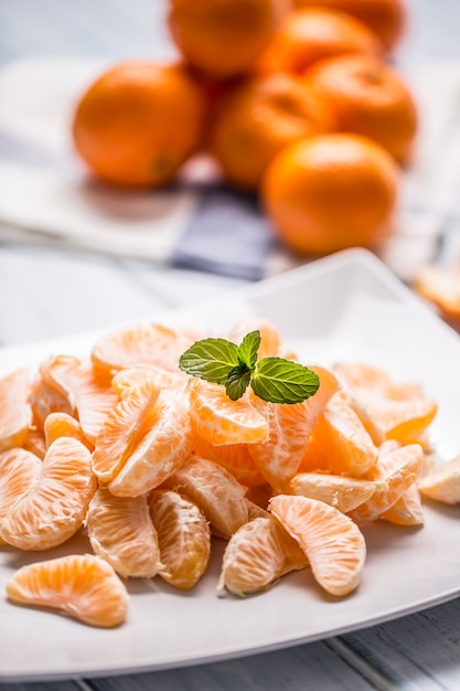 Foto pezzi freschi di mandarini mandarini sul piatto o in una ciotola.