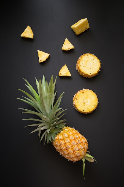 Fresh pineapple on black wood