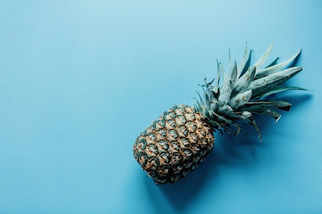 Fresh pineapple on blue background. Above view