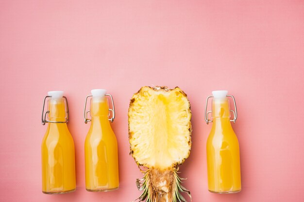 Fresh pineapple juice set, on pink textured summer background, top view flat lay, with copy space for text