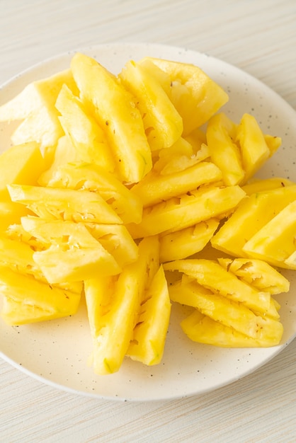 fresh pineapple sliced on white plate