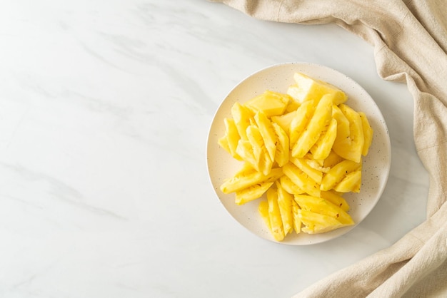 fresh pineapple sliced on white plate