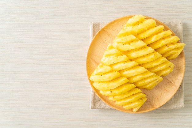 fresh pineapple sliced on wooden plate