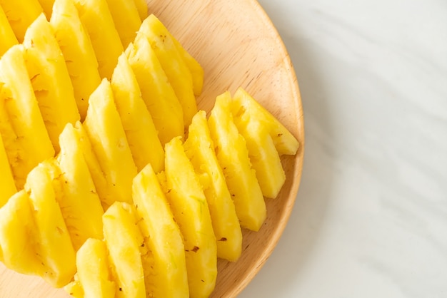 fresh pineapple sliced on wooden plate