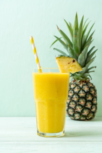 fresh pineapple smoothie glass on wood table