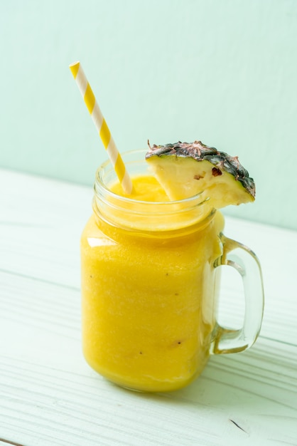 fresh pineapple smoothie glass on wood table