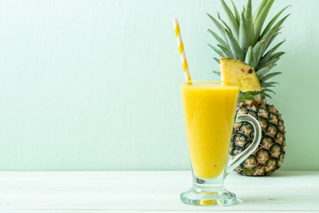 fresh pineapple smoothie glass on wood table