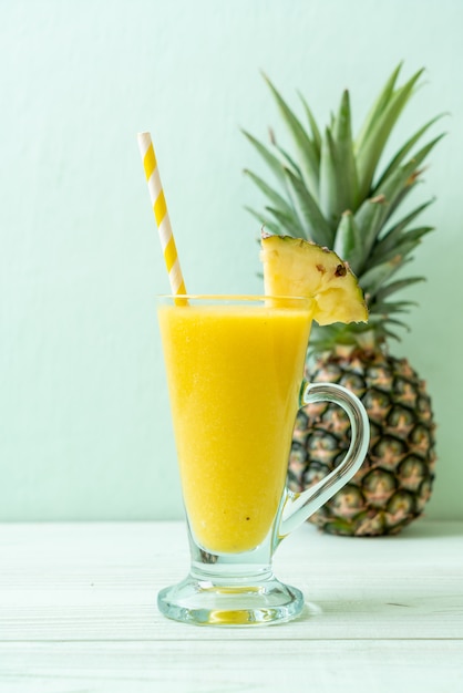 fresh pineapple smoothie glass on wood table