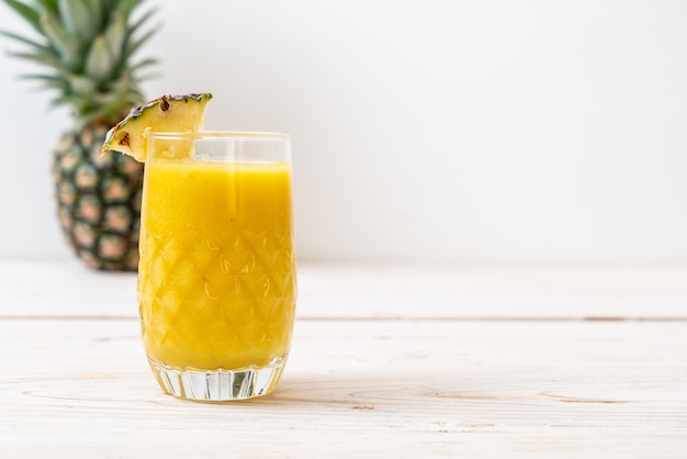 fresh pineapple smoothie glass on wood table