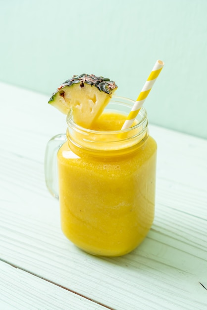 fresh pineapple smoothie glass on wood table