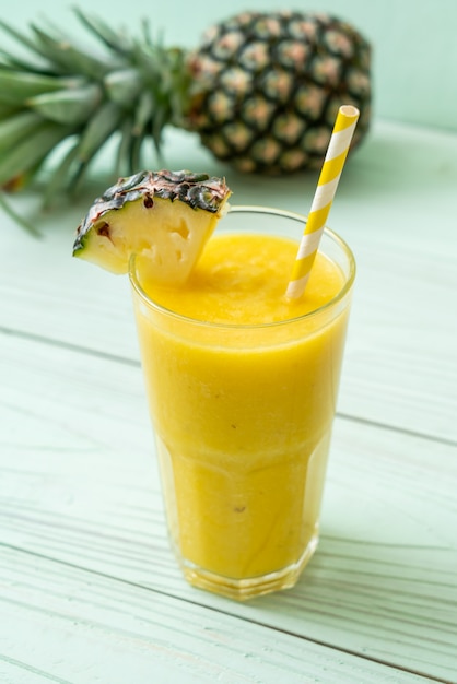 fresh pineapple smoothie glass on wood table