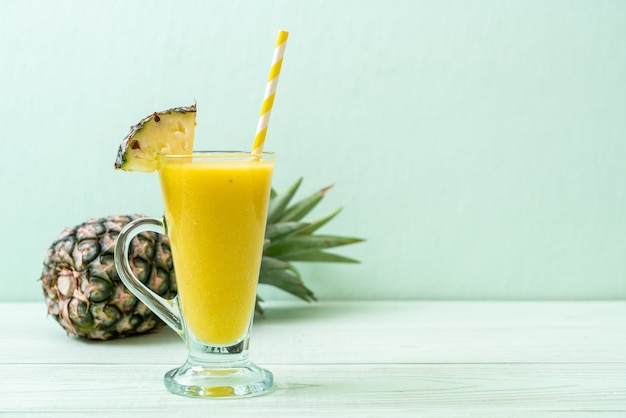 fresh pineapple smoothie glass on wood table