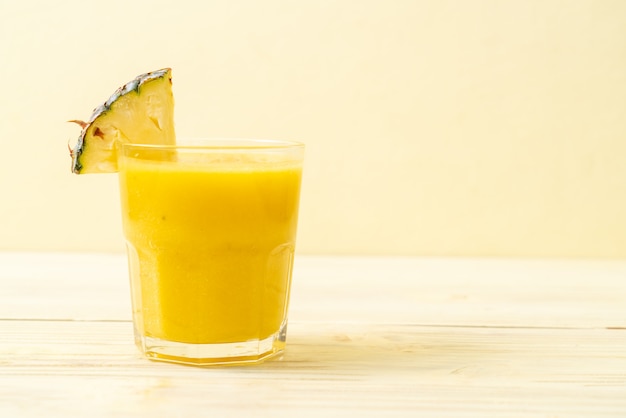 fresh pineapple smoothie glass on wood table