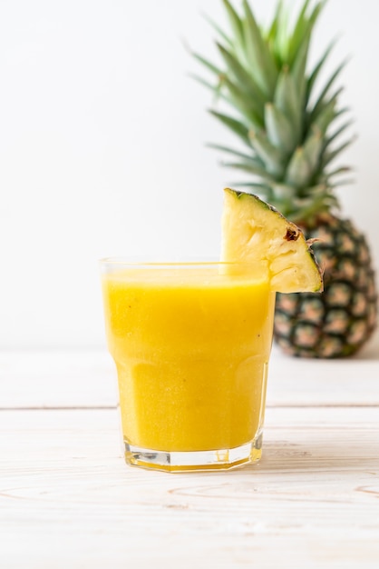 fresh pineapple smoothie glass on wood table