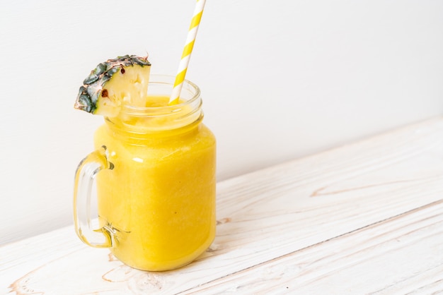 fresh pineapple smoothie glass on wood table