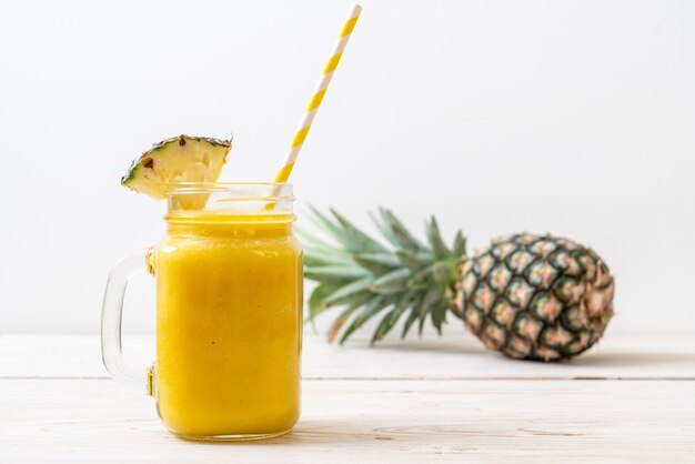 fresh pineapple smoothie glass on wooden table