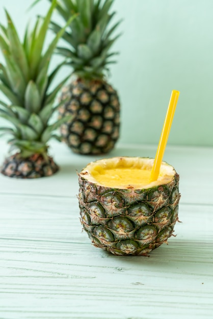 Fresh pineapple smoothie on wooden table