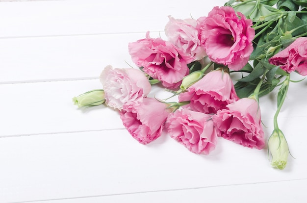 Fresh pink eustoma flowers on white wooden