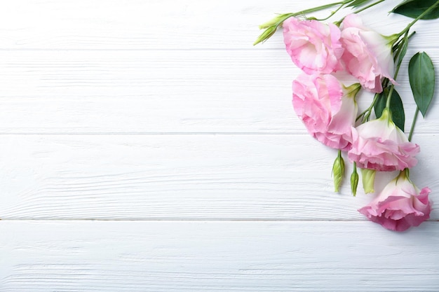 Fresh pink flowers frame on wooden background