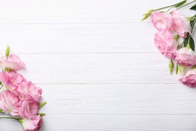 Fresh pink flowers frame on wooden background