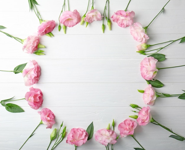 Fresh pink flowers frame on wooden